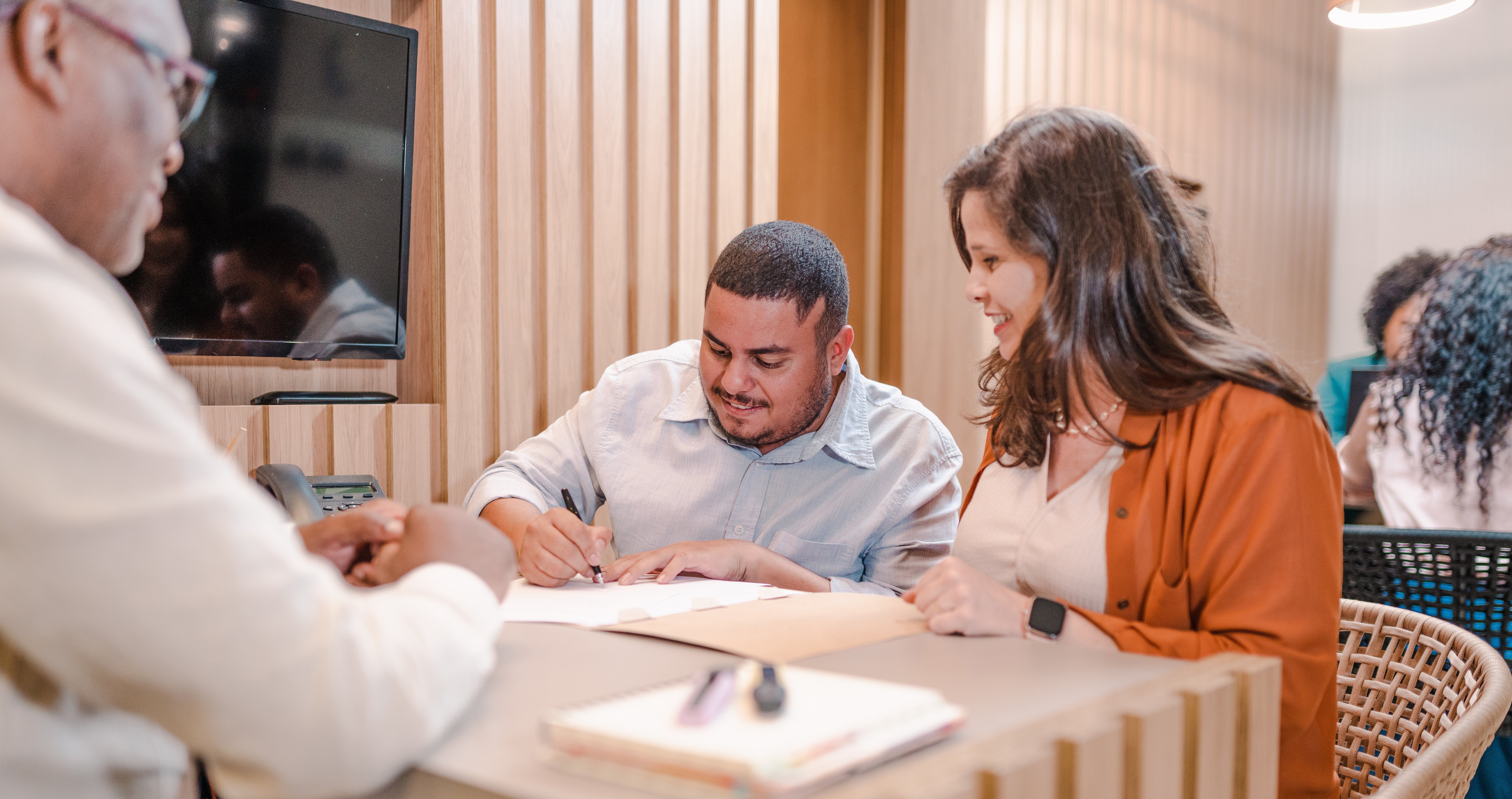 Couple signing papers at a credit union