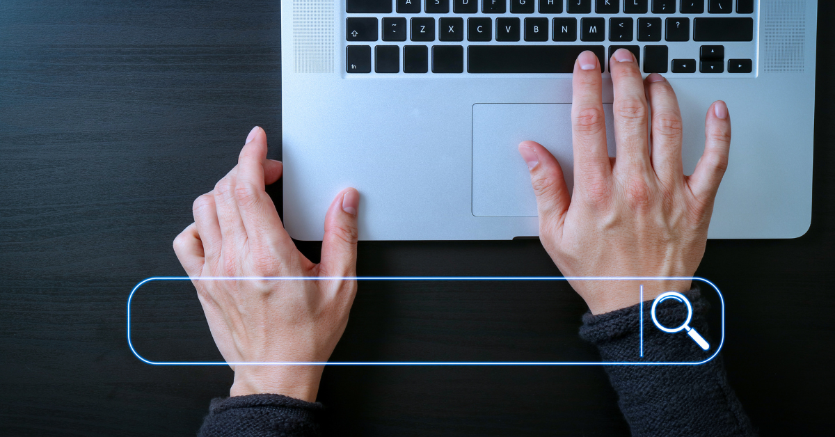 Hands typing on a keyboard with a search bar overlaying the image
