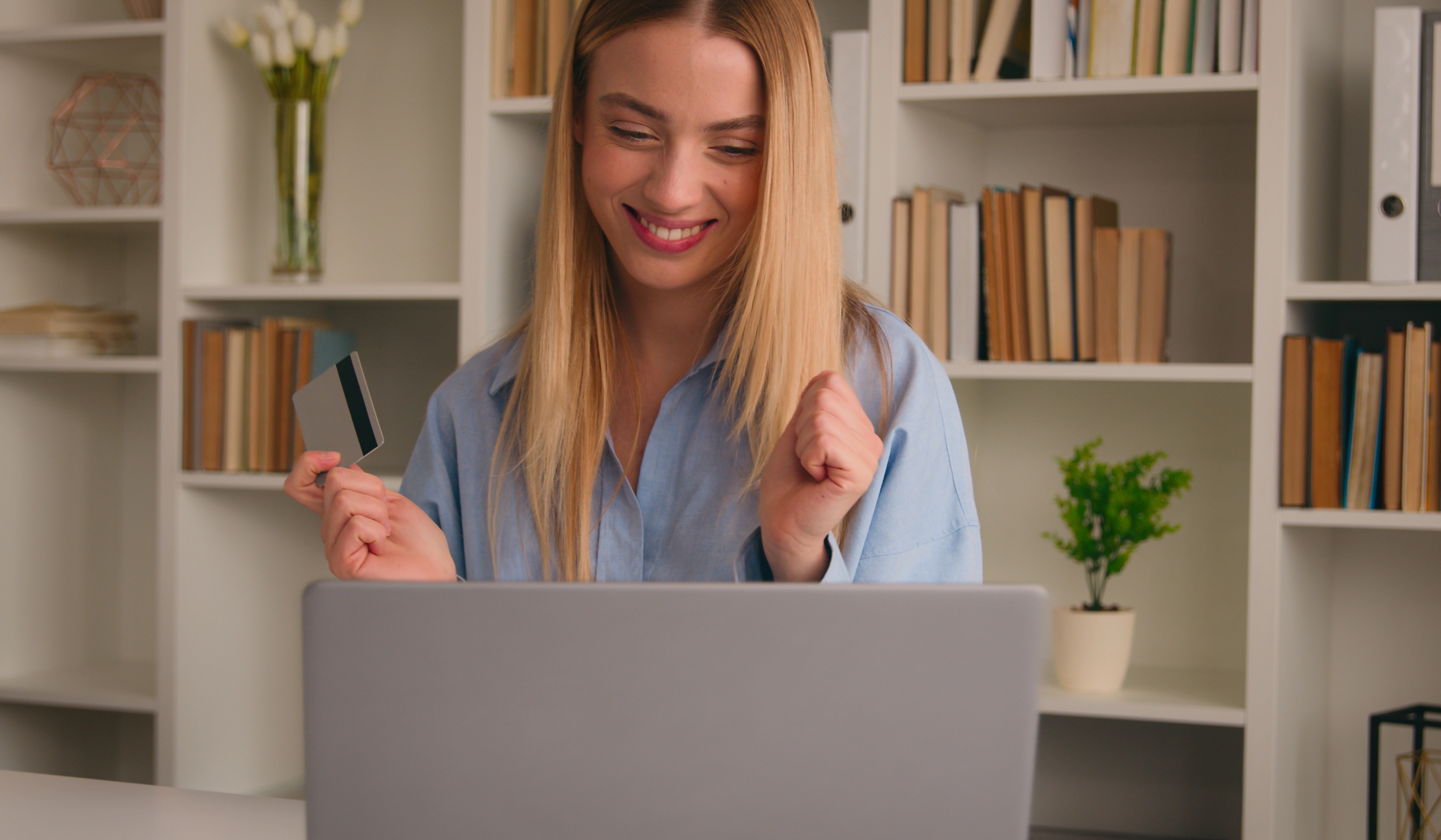 Gen Z girl holding credit card in front of computer